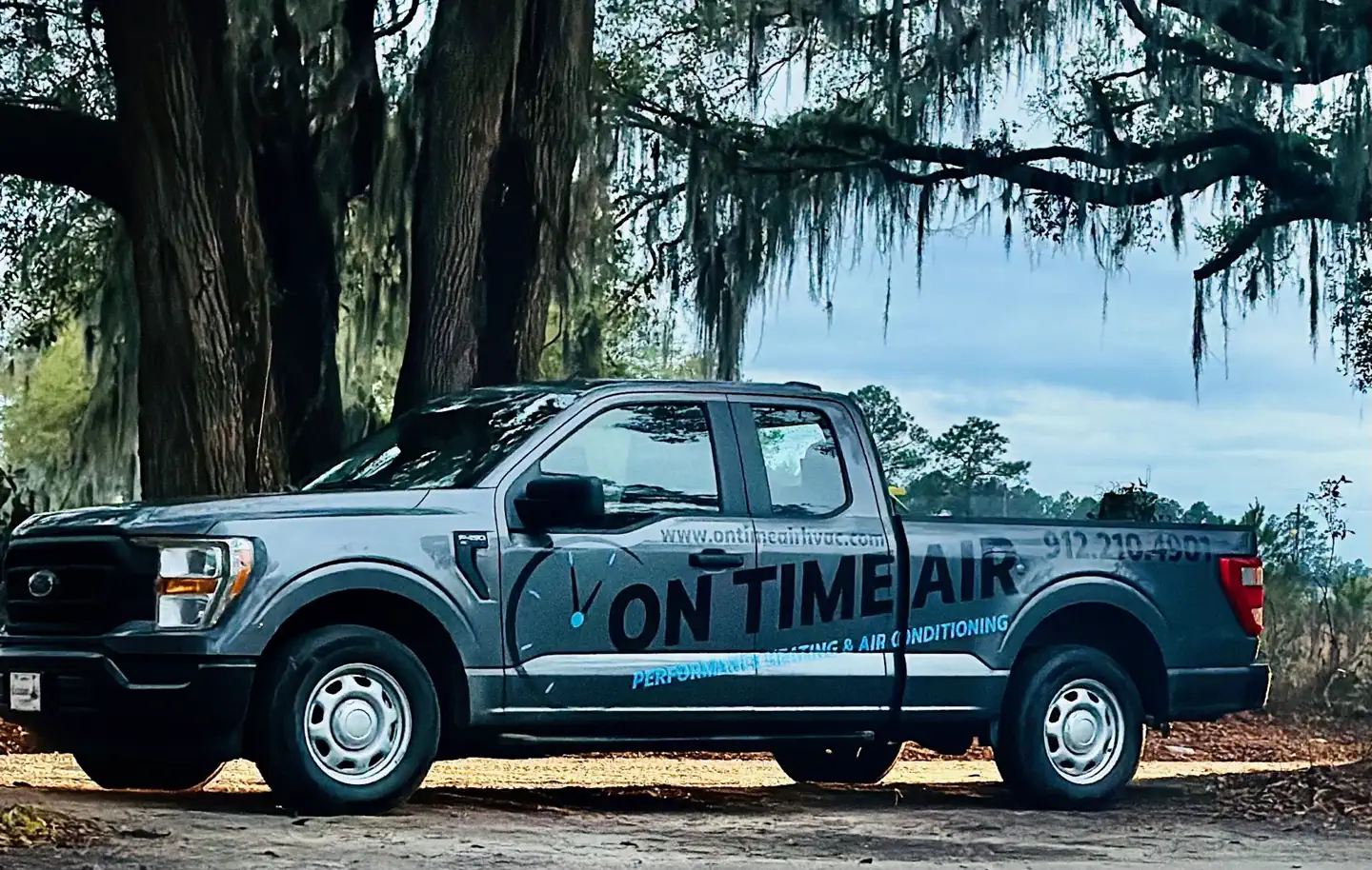 On Time Air service trucks parked under live oaks on Wilmington Island